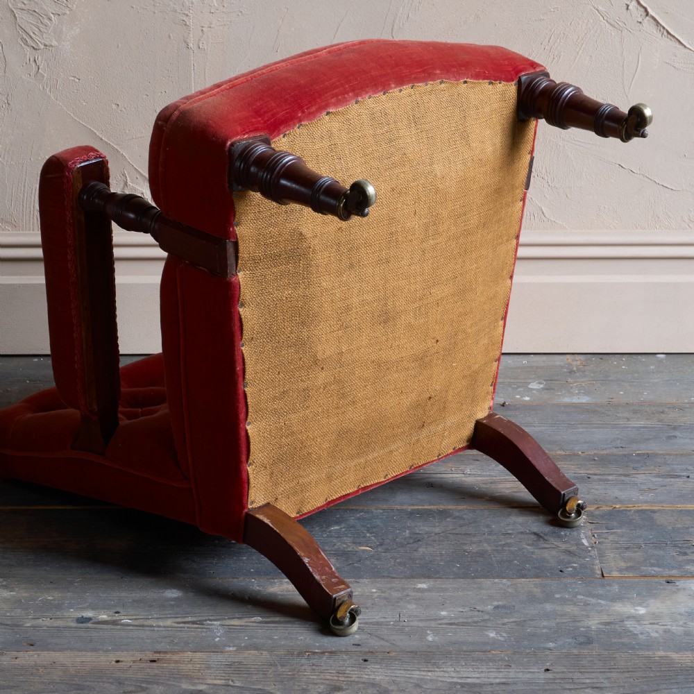 Victorian open armchair featuring deep buttoned rose pink velvet upholstery, turned wooden front legs, and brass castors. View IX