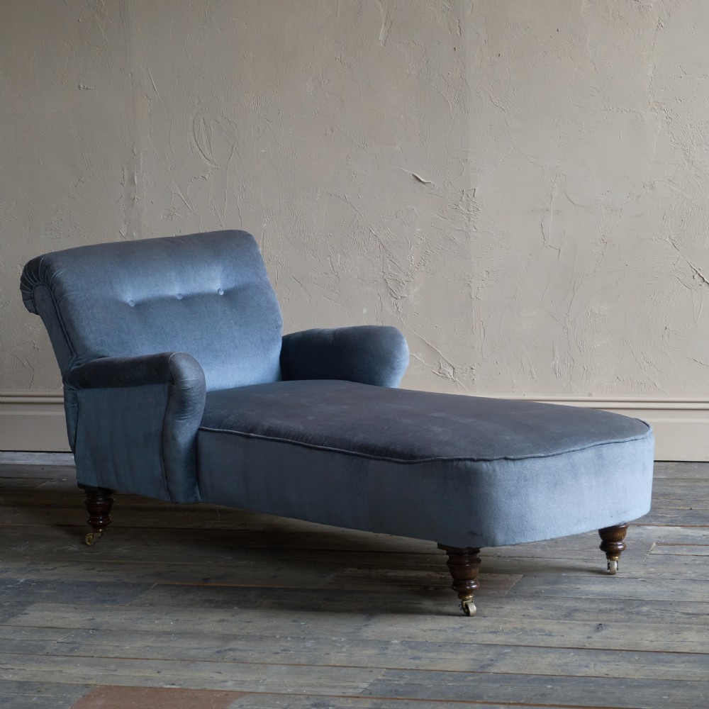 A Victorian slate blue velvet upholstered reclining day bed with a tufted backrest, turned wood legs, and brass castors. View II