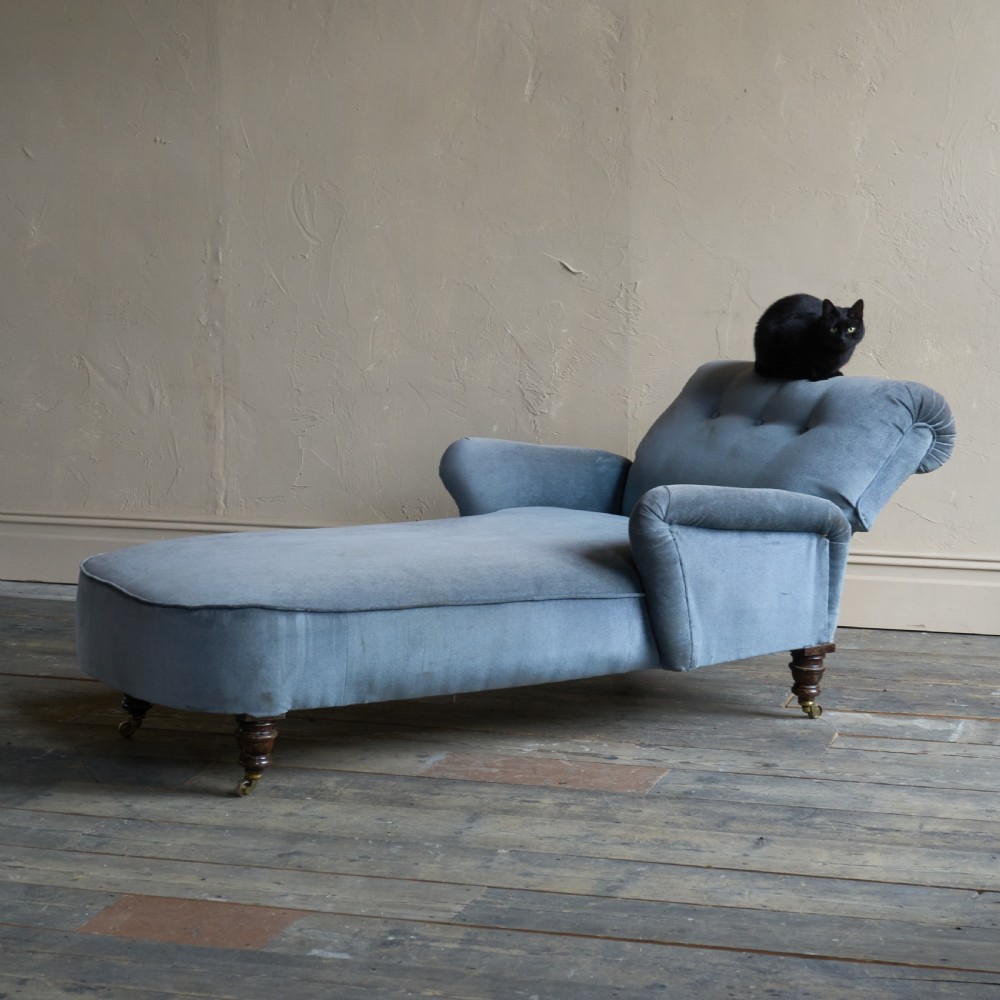 A Victorian slate blue velvet upholstered reclining day bed with a tufted backrest, turned wood legs, and brass castors. View III