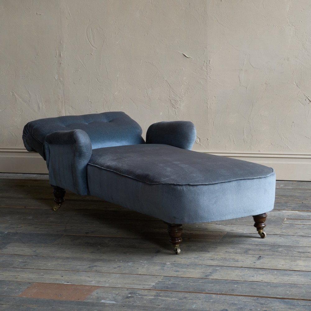 A Victorian slate blue velvet upholstered reclining day bed with a tufted backrest, turned wood legs, and brass castors. View VI