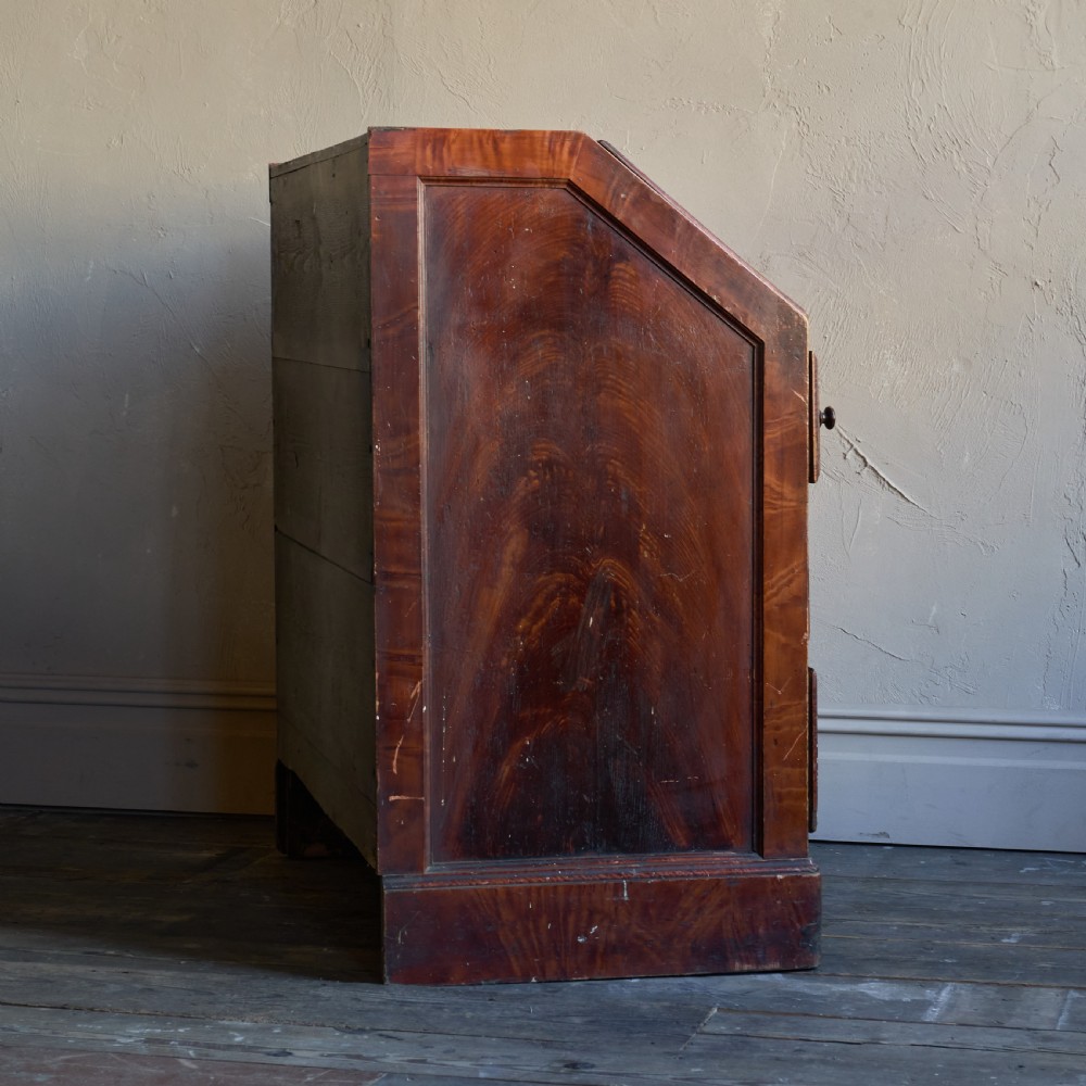 An antique wood bureau with a faux mahogany grain finish featuring a drop-down writing flap, internal pigeonholes, and three lower drawers with round turned handles. View VIII