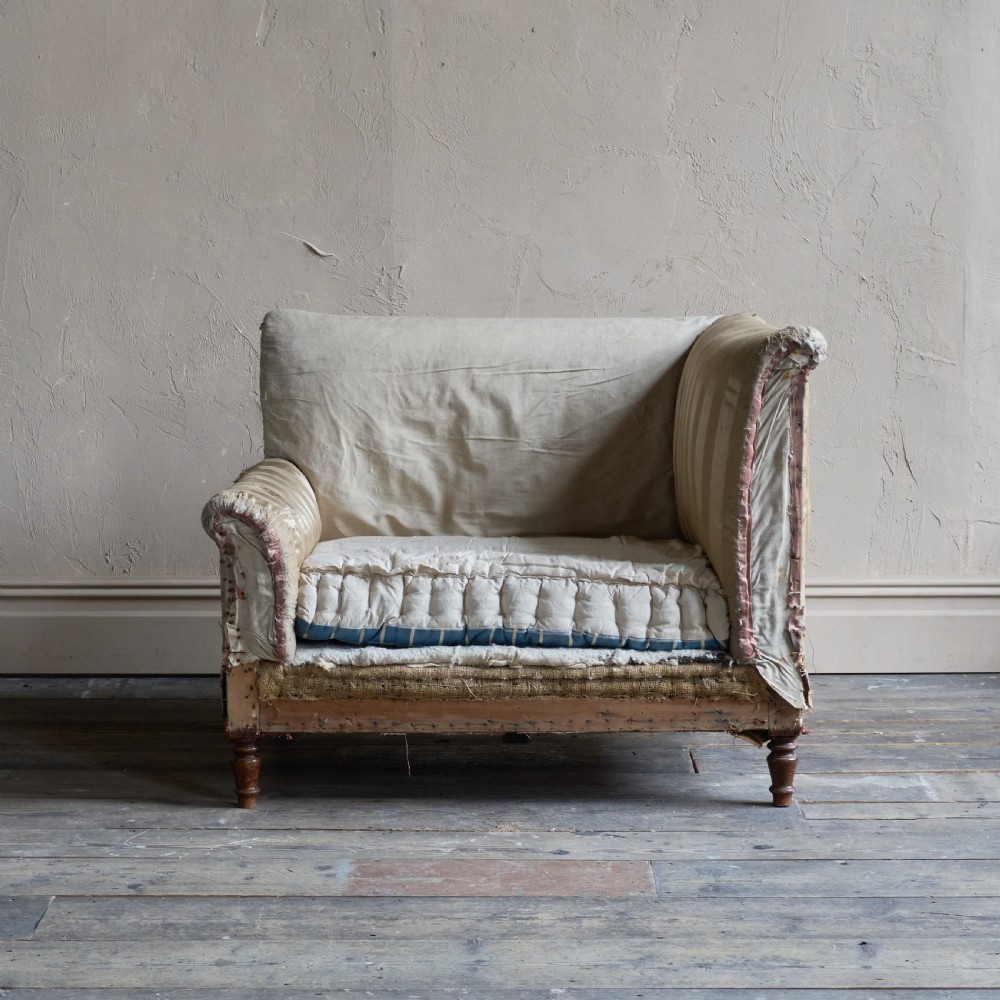 An antique upholstered corner armchair featuring turned wooden legs, striped satin fabric, and a thick tufted squab cushion. View II