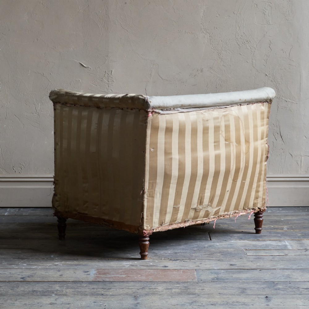An antique upholstered corner armchair featuring turned wooden legs, striped satin fabric, and a thick tufted squab cushion. View IV
