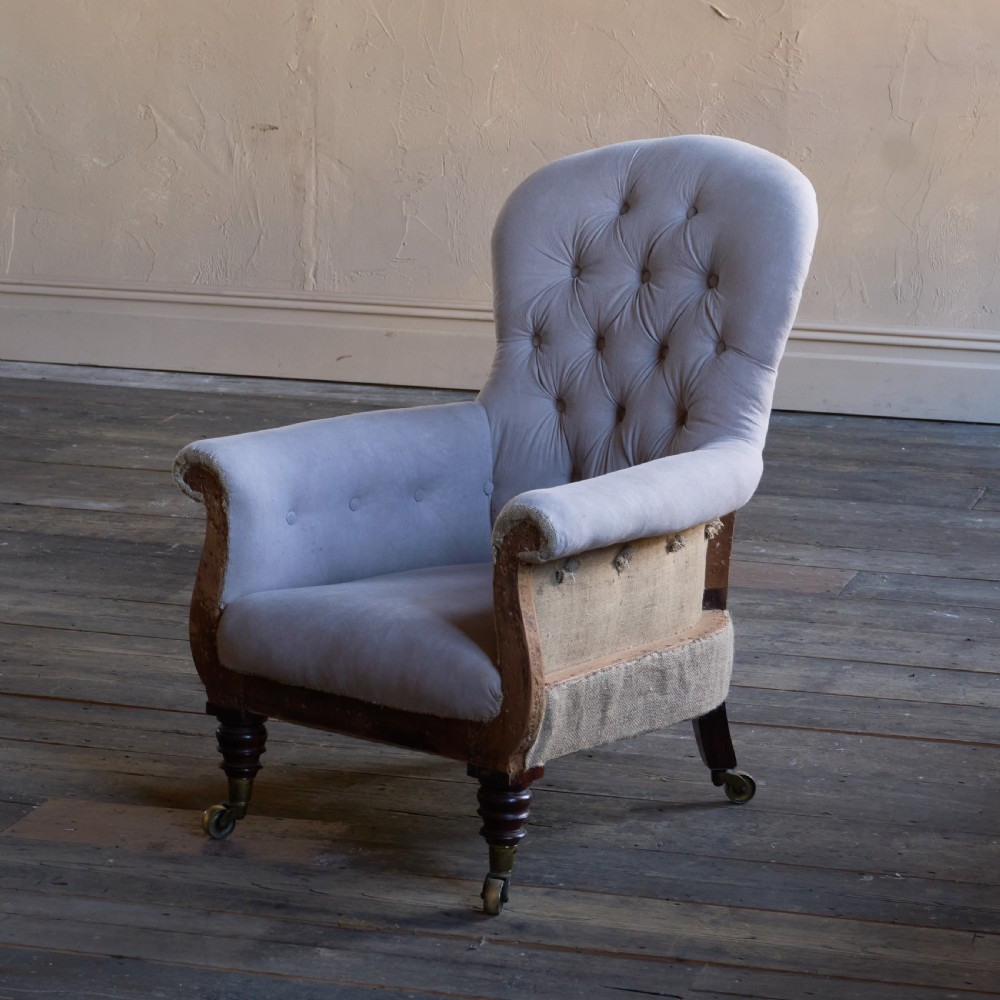 A Regency period button-backed armchair upholstered in pale grey fabric with lyre-shaped front arm supports and turned mahogany legs on brass castors. View II