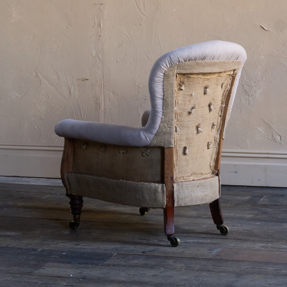 A Regency period button-backed armchair upholstered in pale grey fabric with lyre-shaped front arm supports and turned mahogany legs on brass castors. View IV
