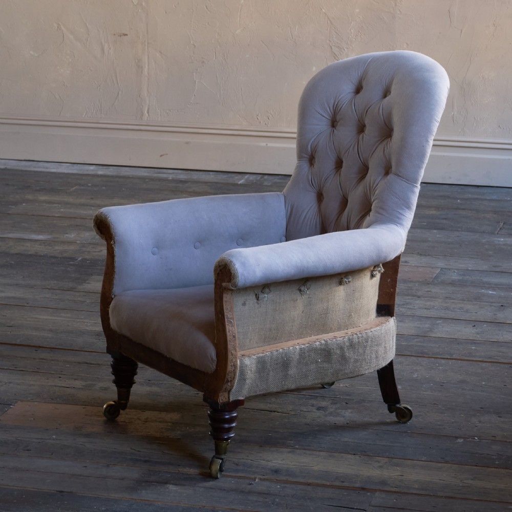 A Regency period button-backed armchair upholstered in pale grey fabric with lyre-shaped front arm supports and turned mahogany legs on brass castors. View VI