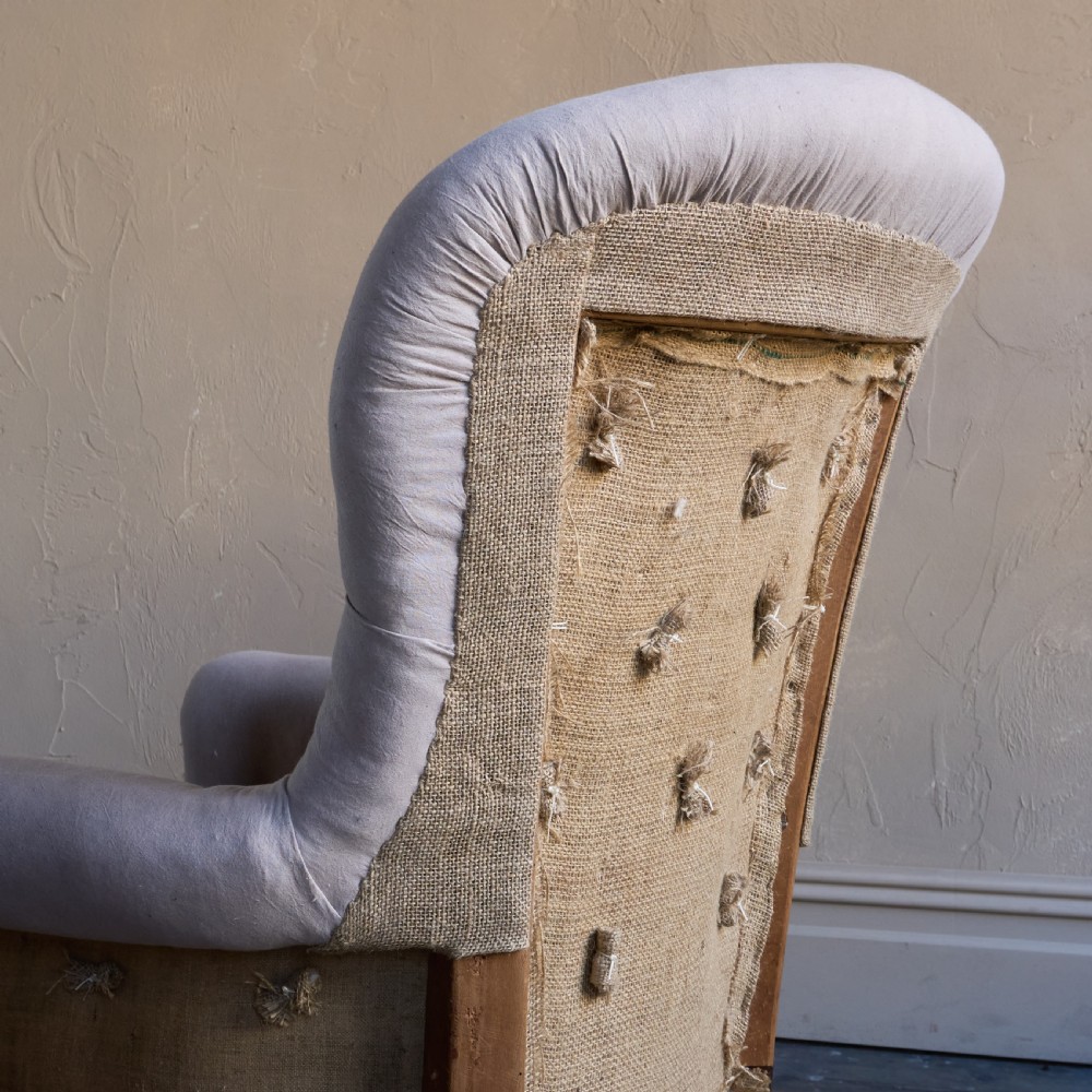A Regency period button-backed armchair upholstered in pale grey fabric with lyre-shaped front arm supports and turned mahogany legs on brass castors. View IX