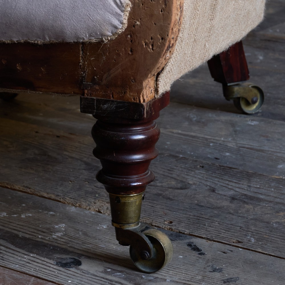 A Regency period button-backed armchair upholstered in pale grey fabric with lyre-shaped front arm supports and turned mahogany legs on brass castors. View X