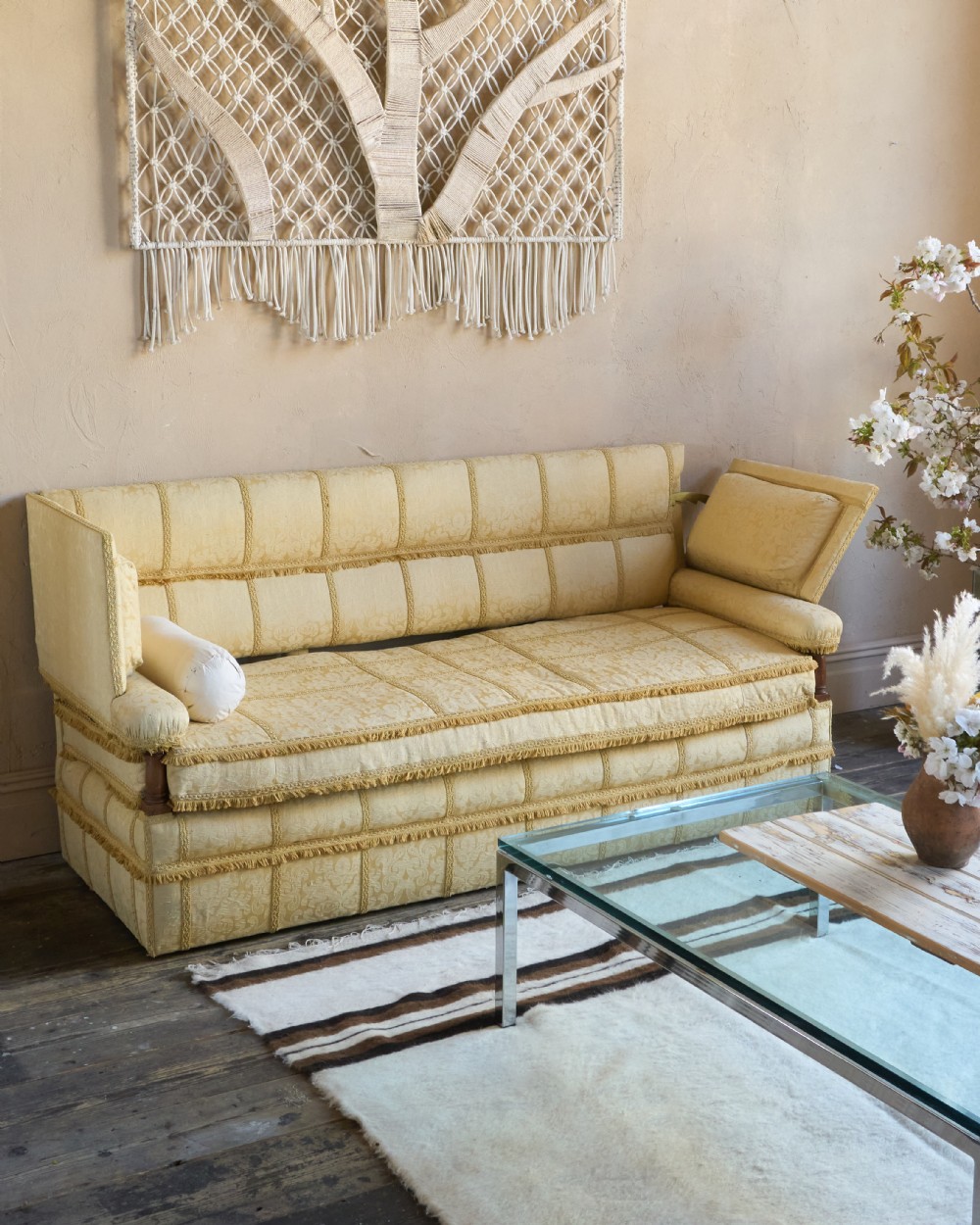 An antique gold damask Knole sofa with high drop-down side arms, fringed trim, and vertical panel upholstery. View II