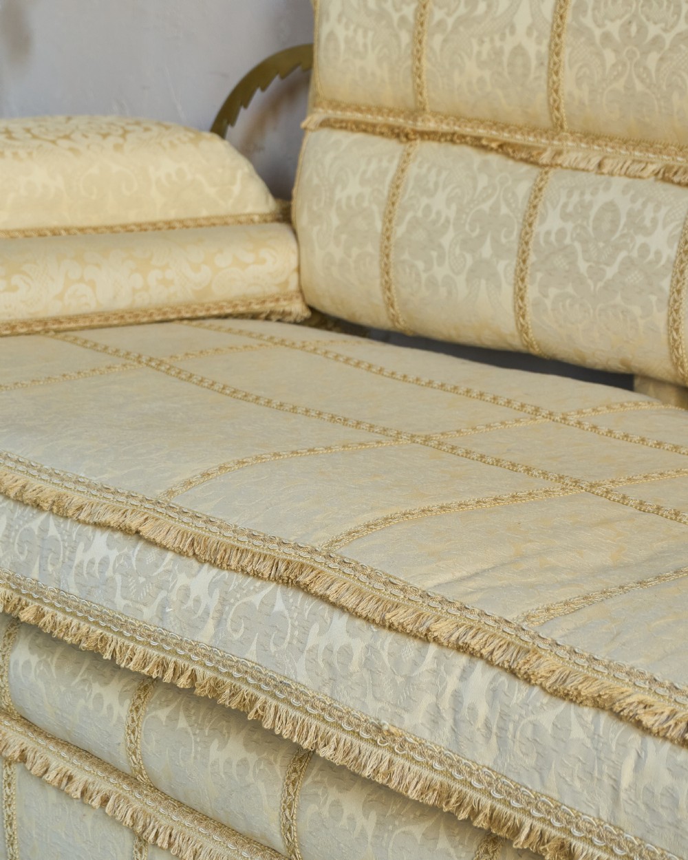 An antique gold damask Knole sofa with high drop-down side arms, fringed trim, and vertical panel upholstery. View VIII