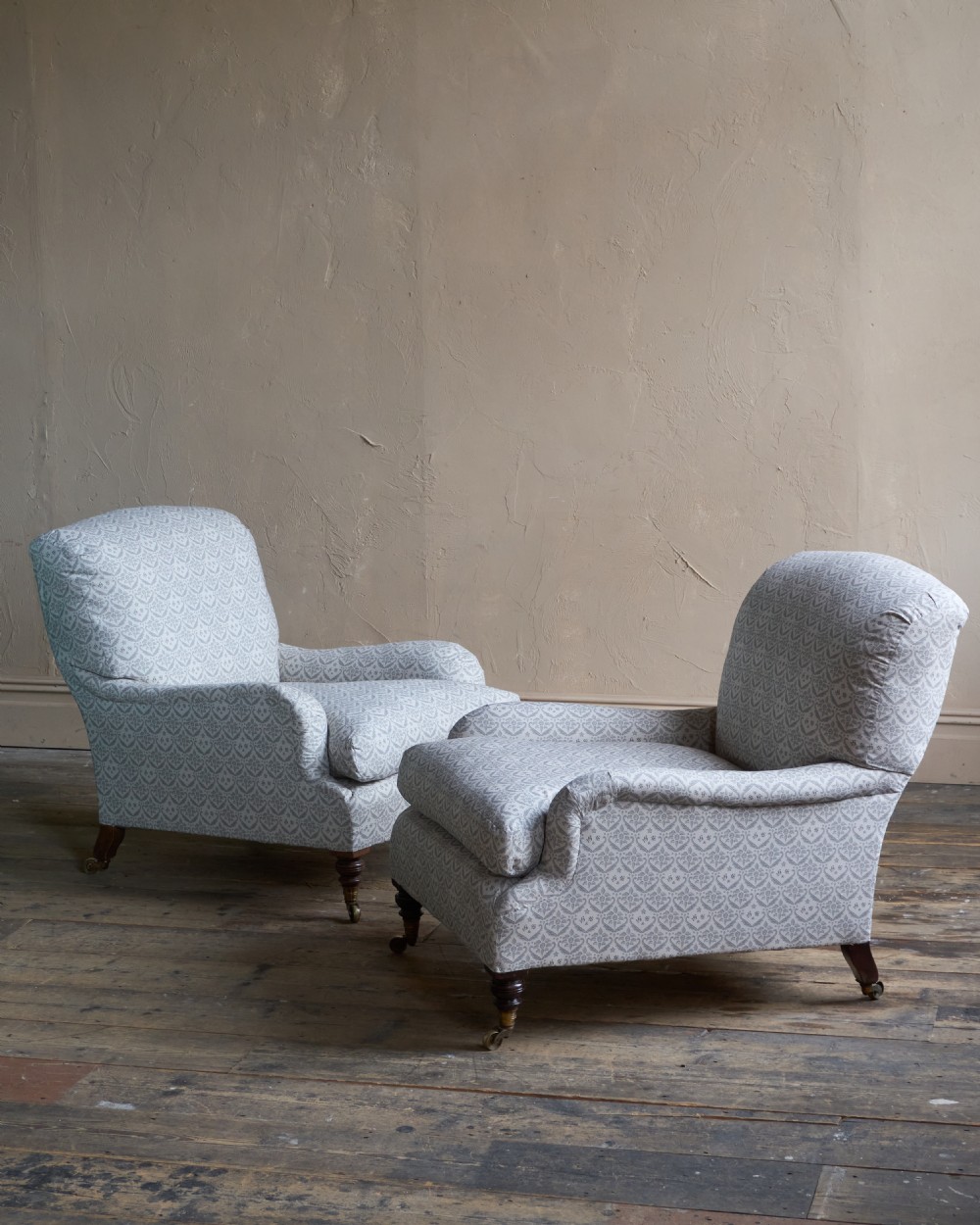 A pair of Victorian Howard and Sons Grafton style armchairs upholstered in patterned grey fabric with turned timber legs on brass castors. View VII