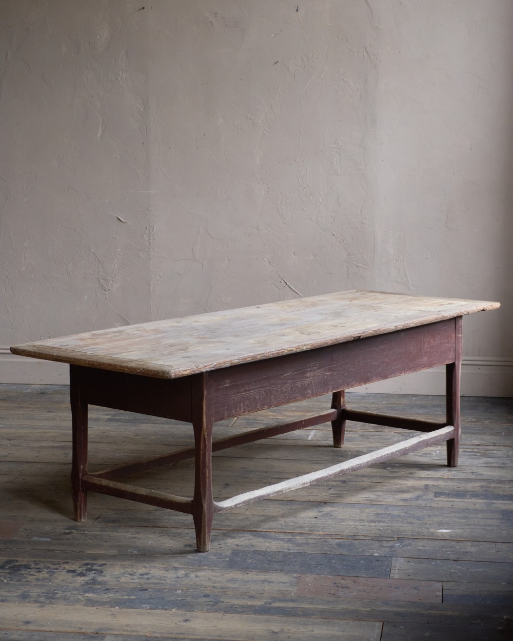 An antique Swedish kitchen table featuring an untreated scrubbed pine top, a single side drawer, and a Falu red painted apron and leg framework with stretchers. View IV