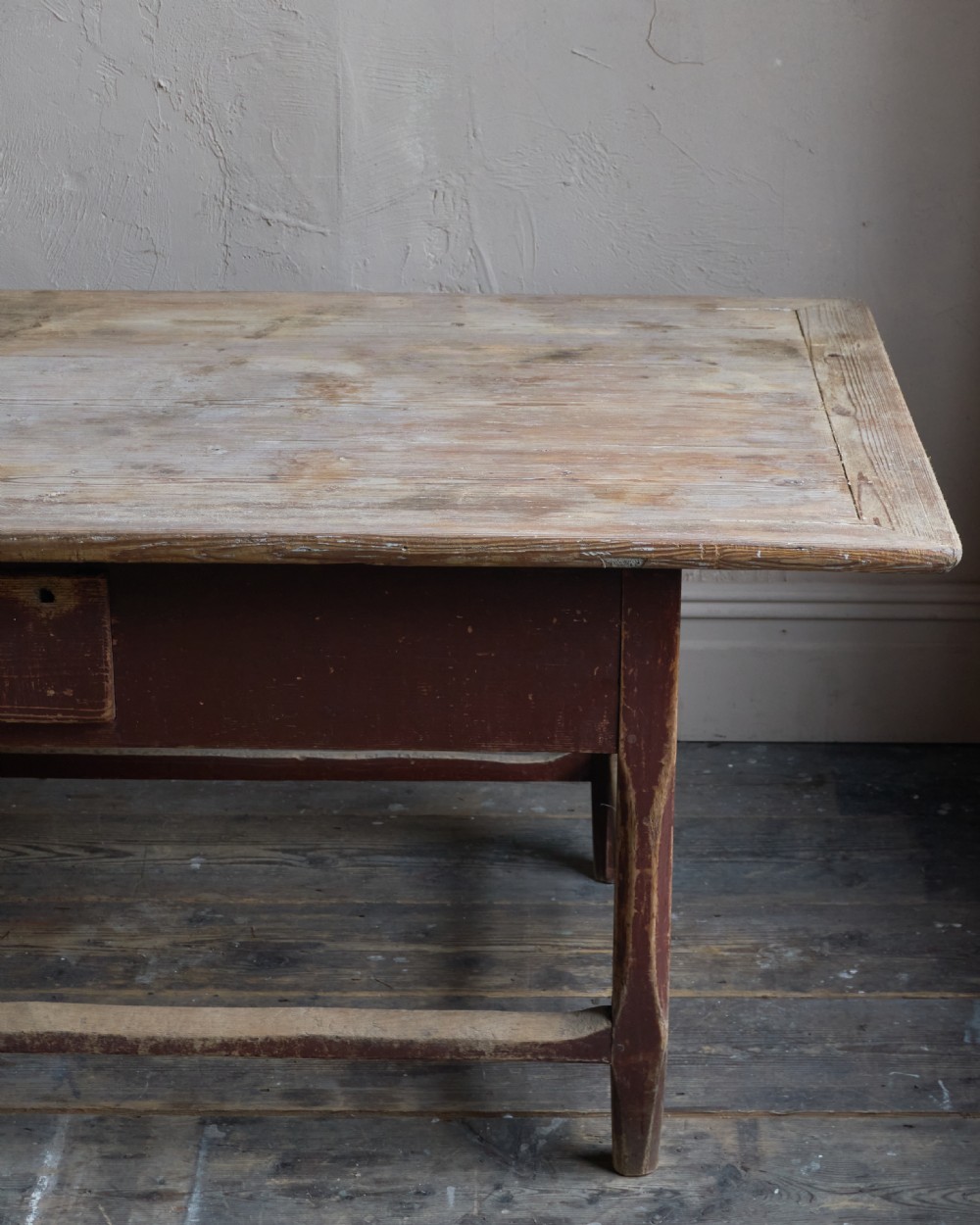 An antique Swedish kitchen table featuring an untreated scrubbed pine top, a single side drawer, and a Falu red painted apron and leg framework with stretchers. View VIII