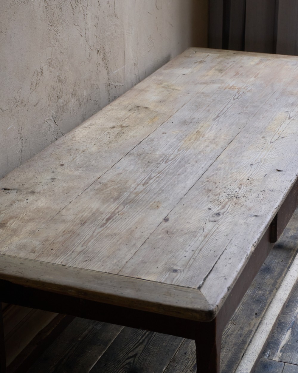 An antique Swedish kitchen table featuring an untreated scrubbed pine top, a single side drawer, and a Falu red painted apron and leg framework with stretchers. View IX