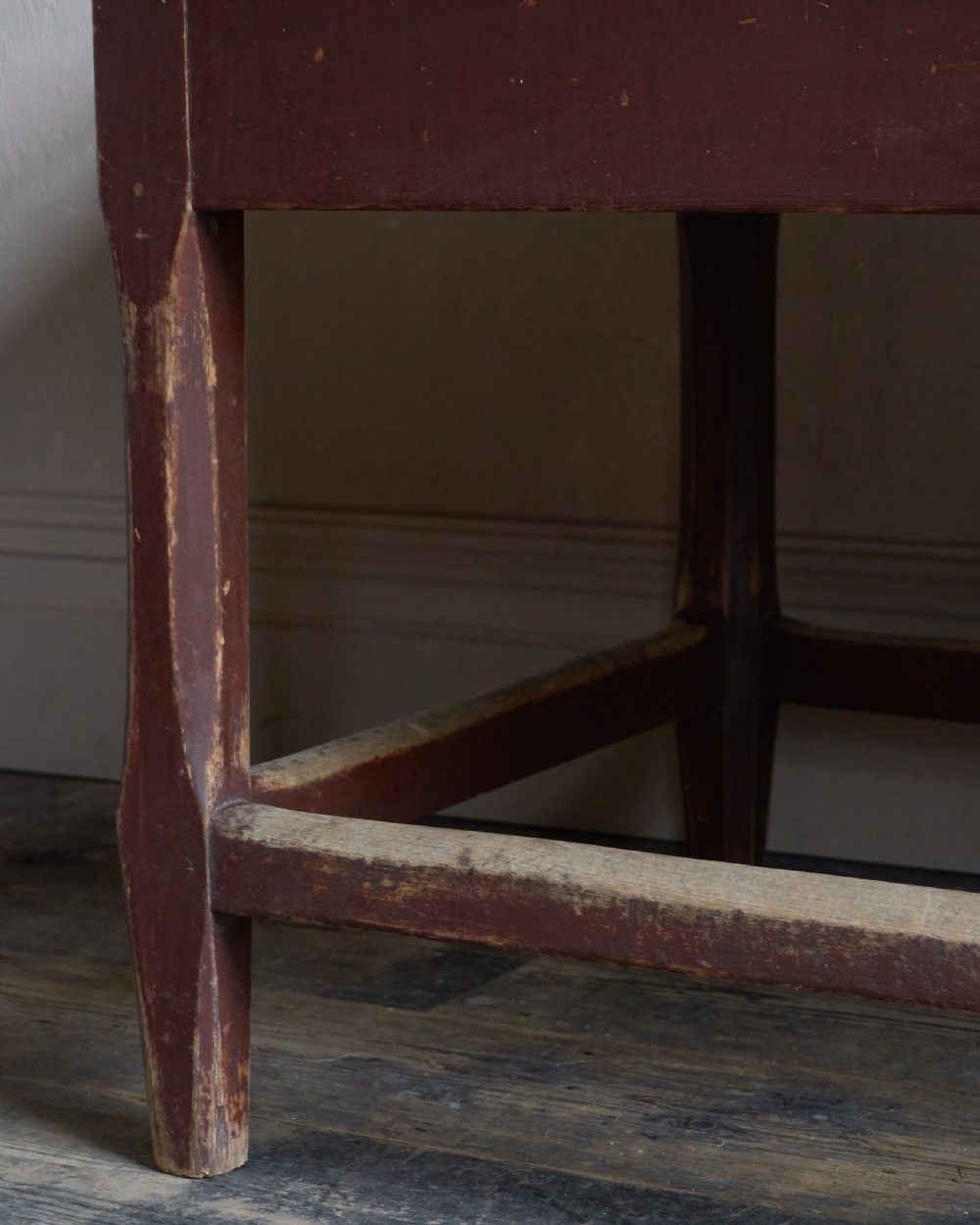 An antique Swedish kitchen table featuring an untreated scrubbed pine top, a single side drawer, and a Falu red painted apron and leg framework with stretchers. View XI