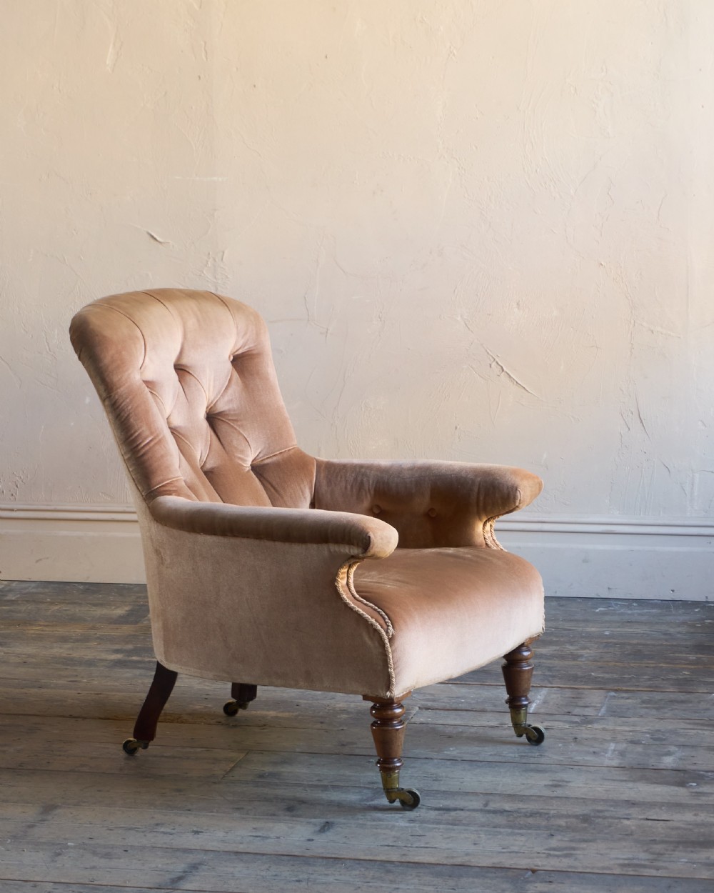 A Regency period spoon back armchair upholstered in taupe velvet with deep buttoning, turned mahogany front legs, and brass castors. View VI