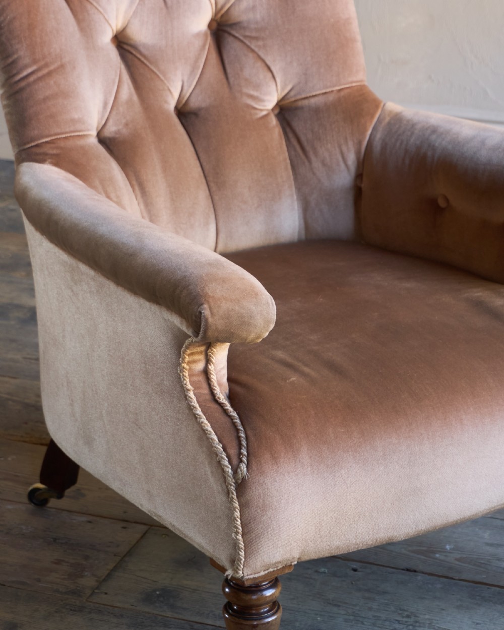 A Regency period spoon back armchair upholstered in taupe velvet with deep buttoning, turned mahogany front legs, and brass castors. View VII