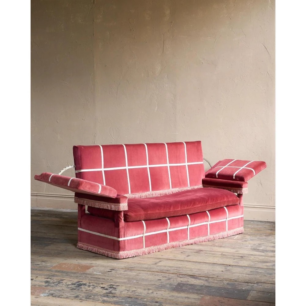 A claret red velvet Knole sofa featuring grid pattern braid trim, fringe edging, and adjustable drop-down armrests with metal ratchets.