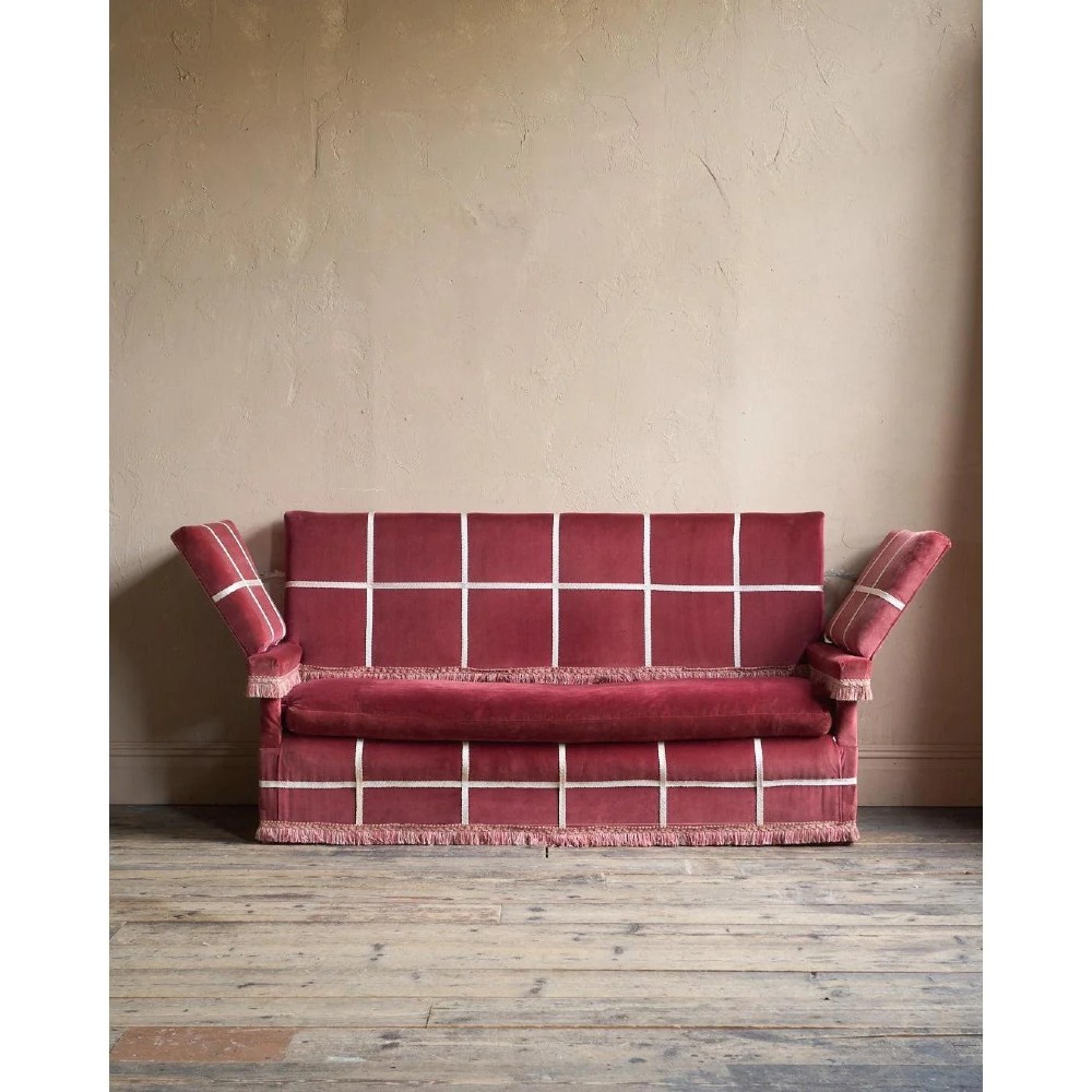 A claret red velvet Knole sofa featuring grid pattern braid trim, fringe edging, and adjustable drop-down armrests with metal ratchets. View IV