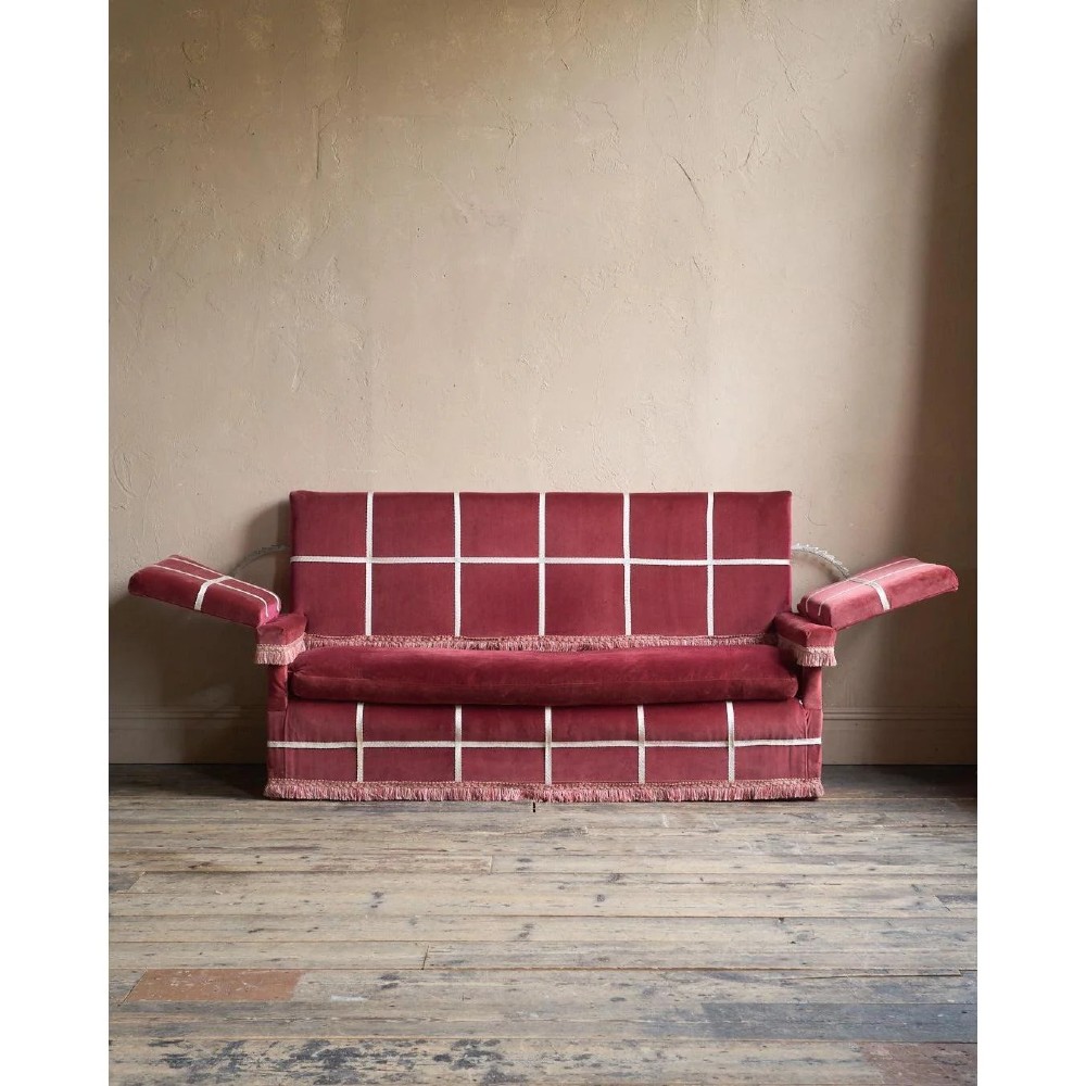 A claret red velvet Knole sofa featuring grid pattern braid trim, fringe edging, and adjustable drop-down armrests with metal ratchets. View V