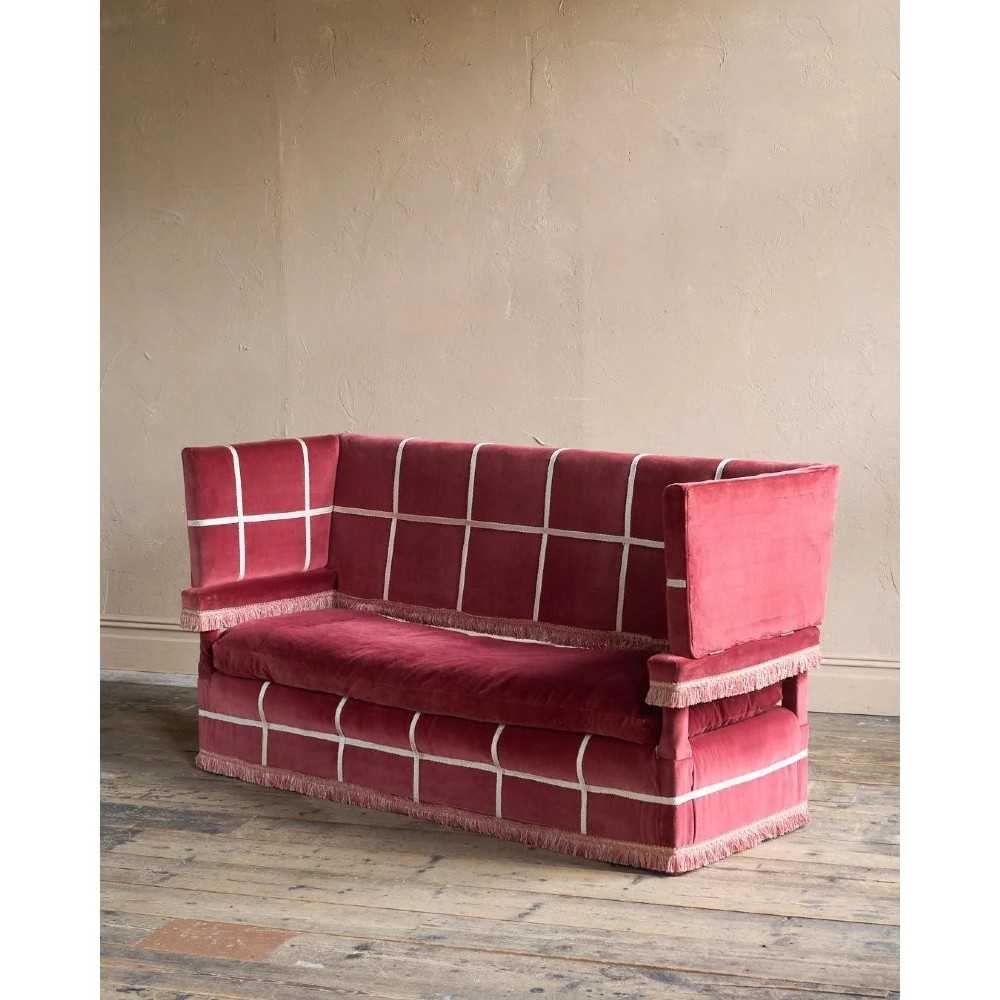 A claret red velvet Knole sofa featuring grid pattern braid trim, fringe edging, and adjustable drop-down armrests with metal ratchets. View VI