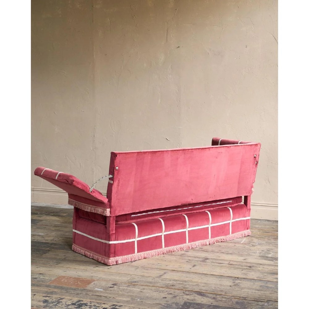 A claret red velvet Knole sofa featuring grid pattern braid trim, fringe edging, and adjustable drop-down armrests with metal ratchets. View VIII
