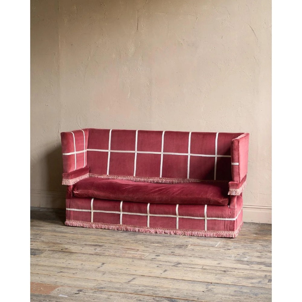A claret red velvet Knole sofa featuring grid pattern braid trim, fringe edging, and adjustable drop-down armrests with metal ratchets. View IX