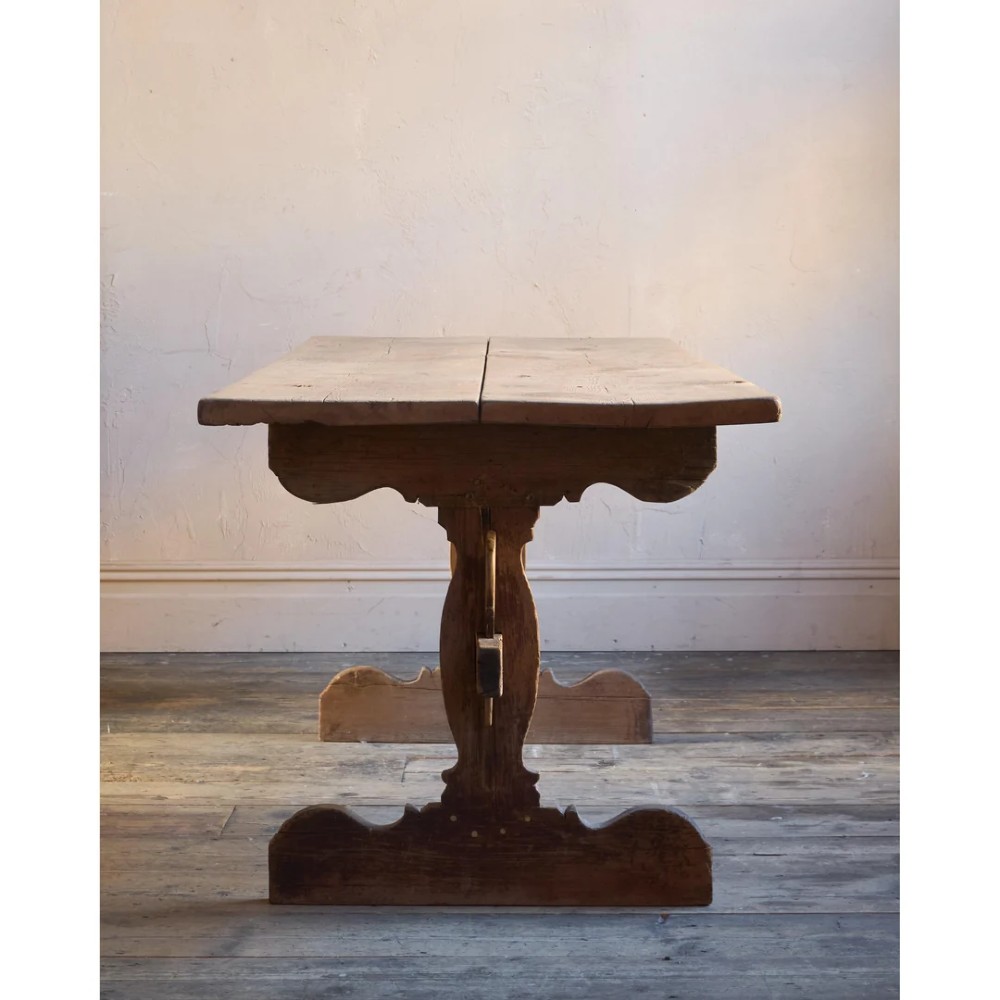 An 18th-century Swedish pine dining table featuring a rectangular plank top resting on a sculpted trestle base with a central stretcher. View IV