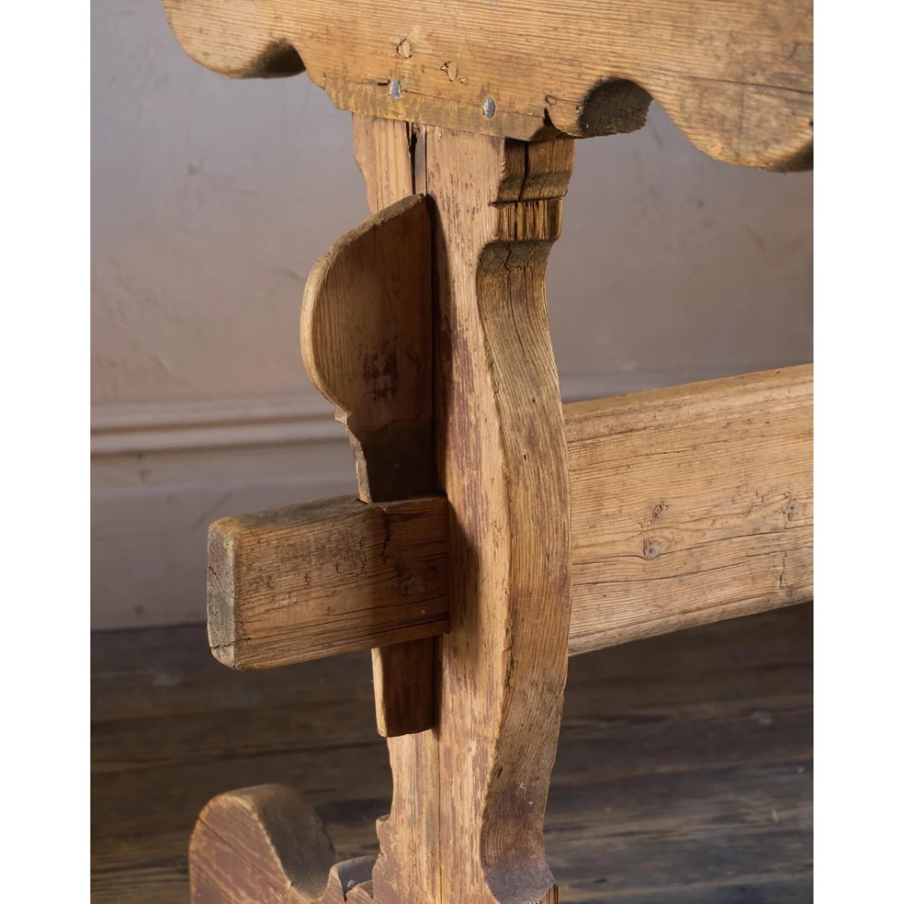 An 18th-century Swedish pine dining table featuring a rectangular plank top resting on a sculpted trestle base with a central stretcher. View VI