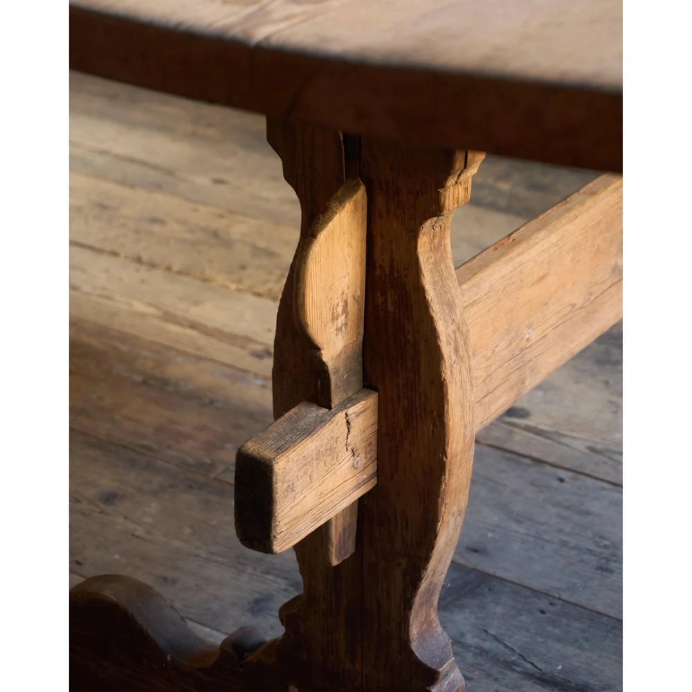 An 18th-century Swedish pine dining table featuring a rectangular plank top resting on a sculpted trestle base with a central stretcher. View IX