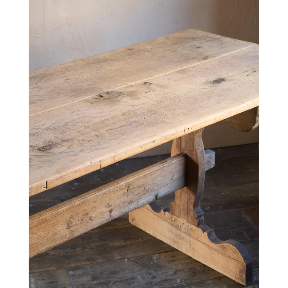 An 18th-century Swedish pine dining table featuring a rectangular plank top resting on a sculpted trestle base with a central stretcher. View X