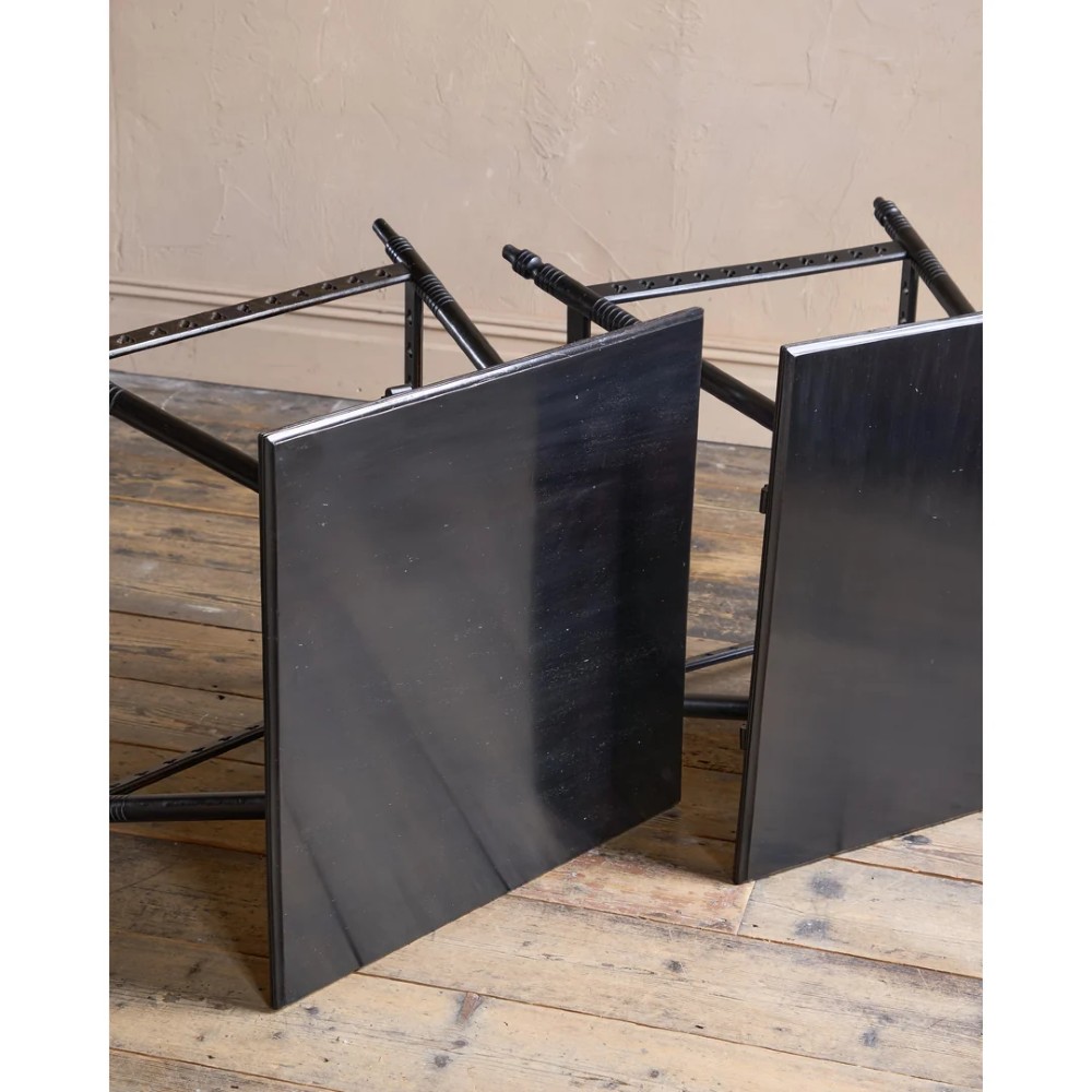 A matched pair of square ebonised wooden side tables with splayed turned legs and decorative pierced lower stretchers. View VII