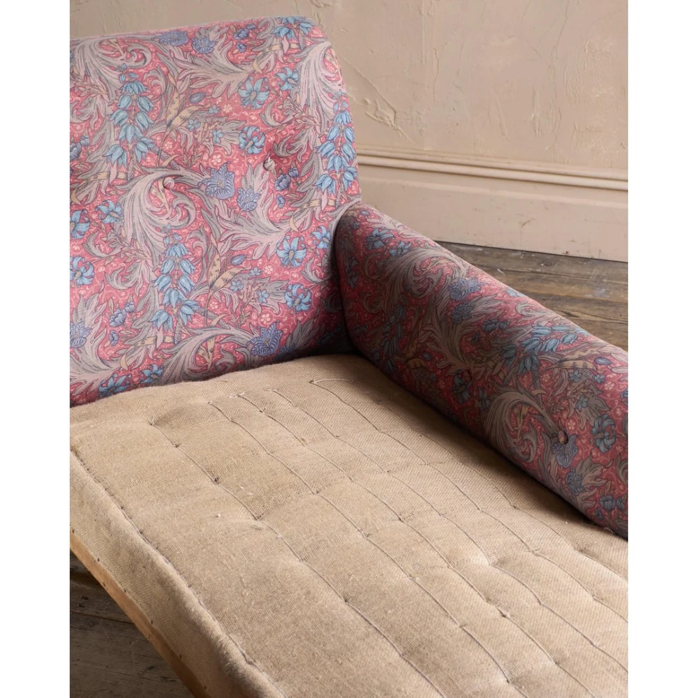 An antique Victorian chaise longue by Howard and Sons featuring patterned fabric upholstery, a single armrest, turned legs, and brass castors. View XI