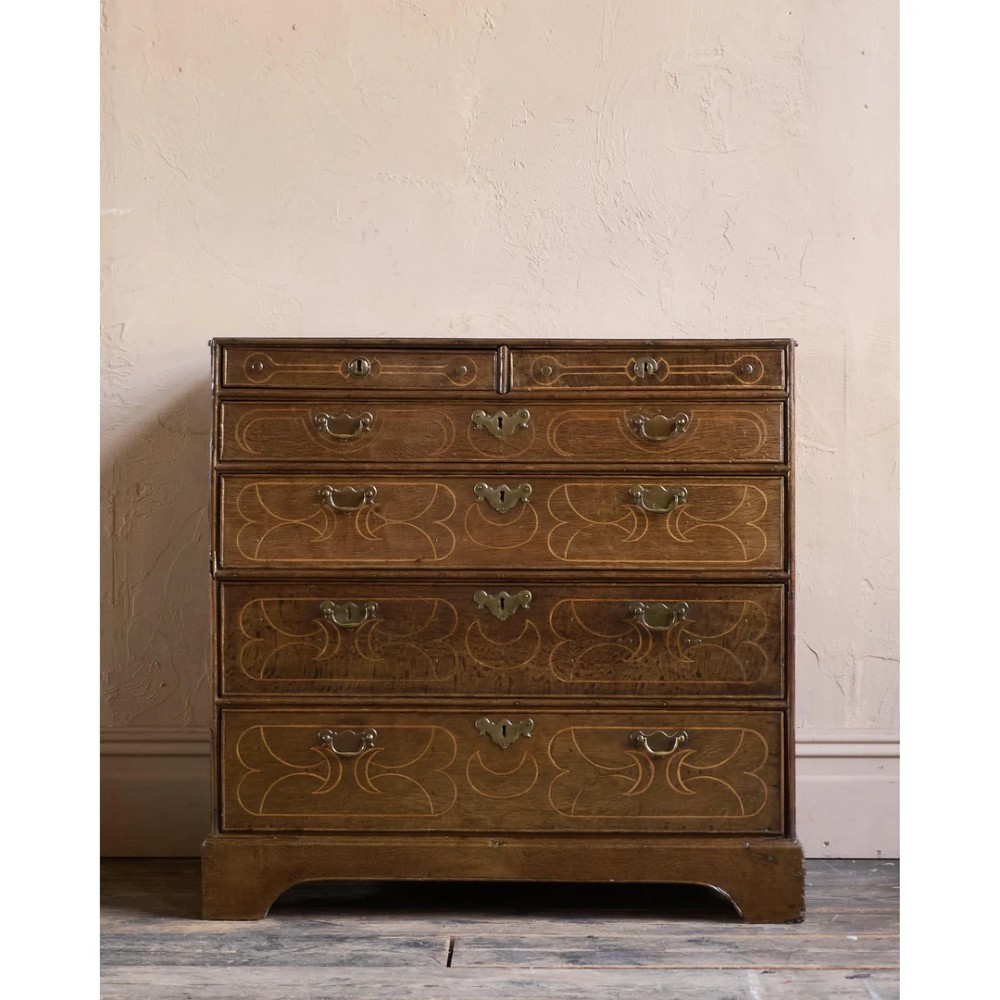 A late 17th-century William and Mary oak chest of drawers featuring geometric scrollwork inlay and brass drop handles. View III