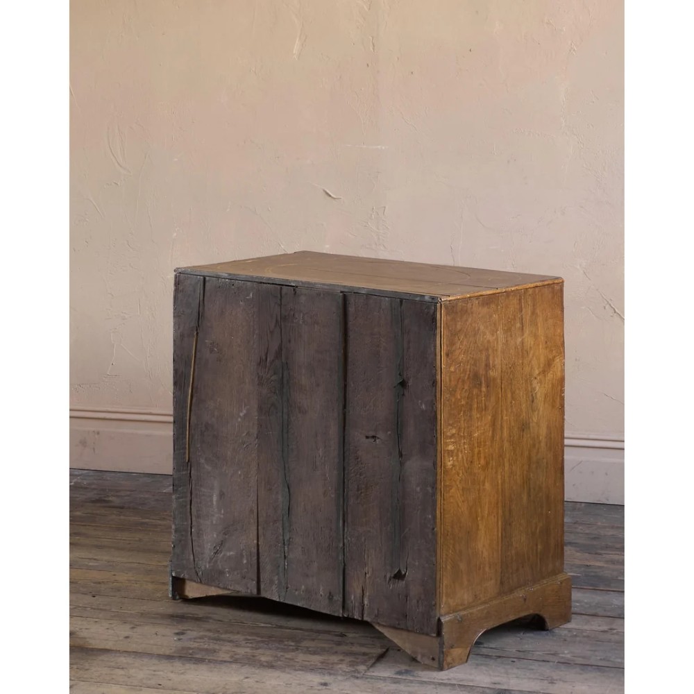 A late 17th-century William and Mary oak chest of drawers featuring geometric scrollwork inlay and brass drop handles. View VI