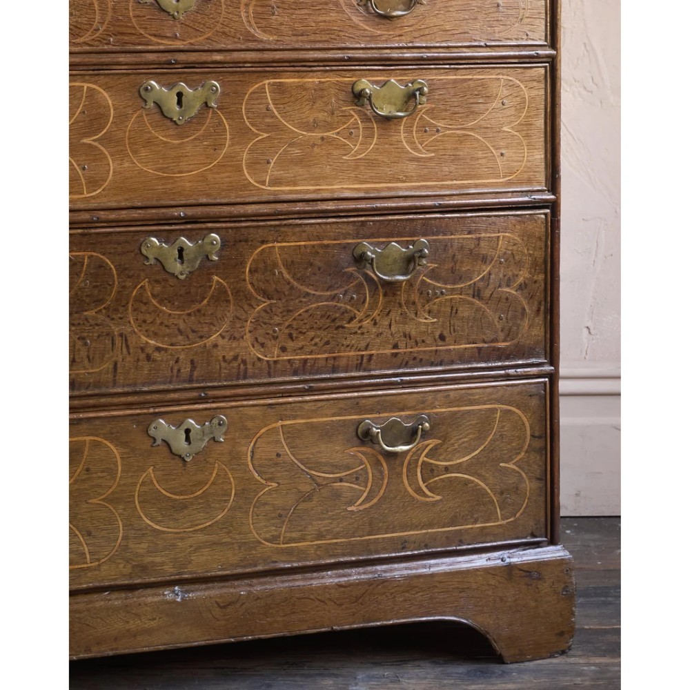 A late 17th-century William and Mary oak chest of drawers featuring geometric scrollwork inlay and brass drop handles. View VIII