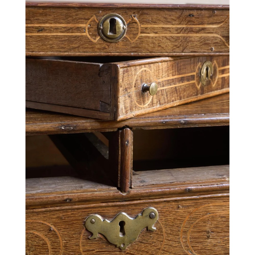 A late 17th-century William and Mary oak chest of drawers featuring geometric scrollwork inlay and brass drop handles. View XI