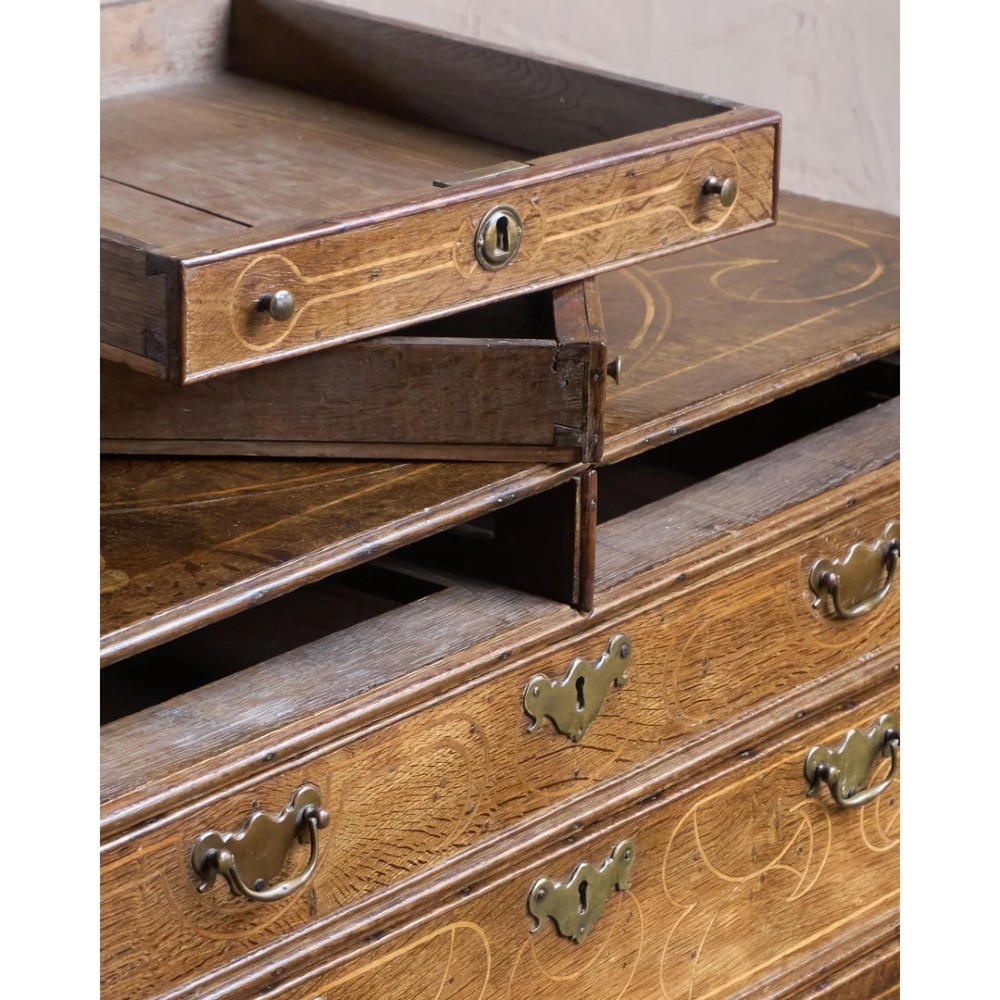 A late 17th-century William and Mary oak chest of drawers featuring geometric scrollwork inlay and brass drop handles. View XII