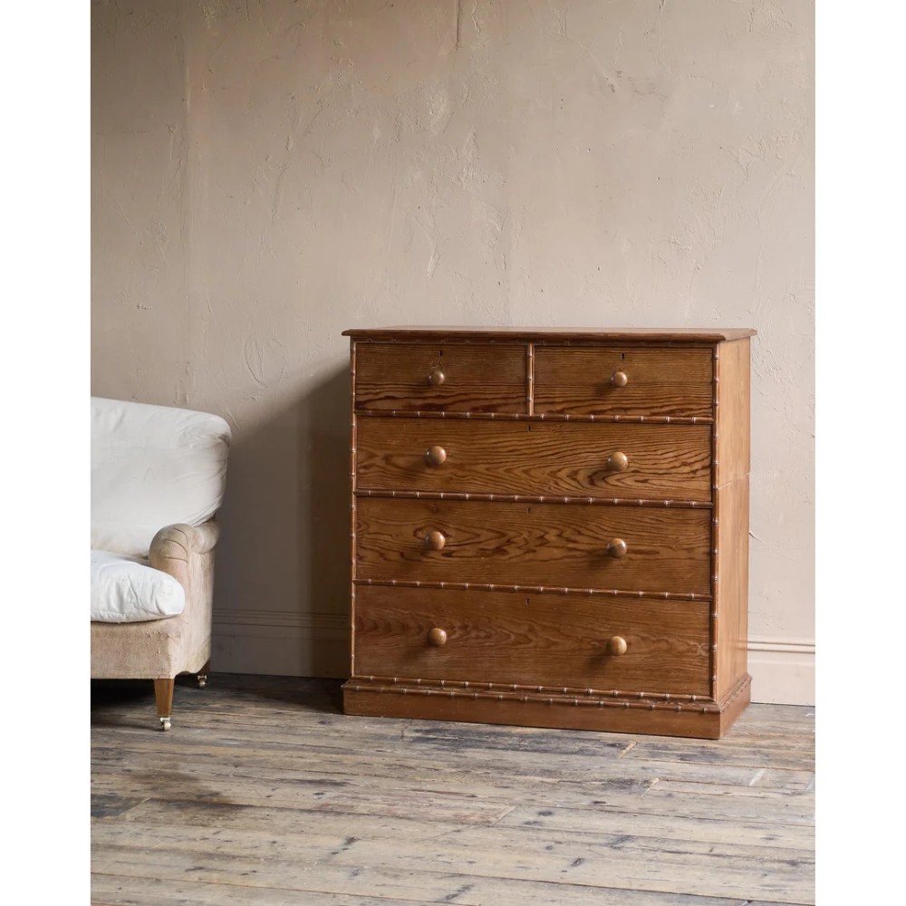 A Victorian pitch pine chest of drawers featuring two short over three long drawers framed with carved faux bamboo mouldings and turned wooden knobs. View III