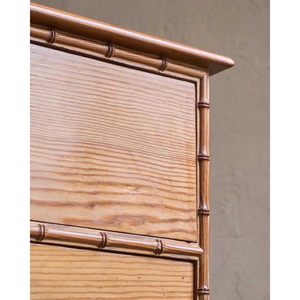 A Victorian pitch pine chest of drawers featuring two short over three long drawers framed with carved faux bamboo mouldings and turned wooden knobs. View IX