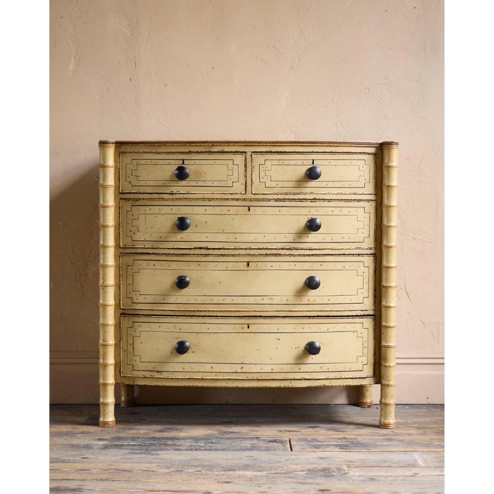A Regency pale yellow painted chest of drawers featuring simulated bamboo turned corner columns and dark turned knobs. View II
