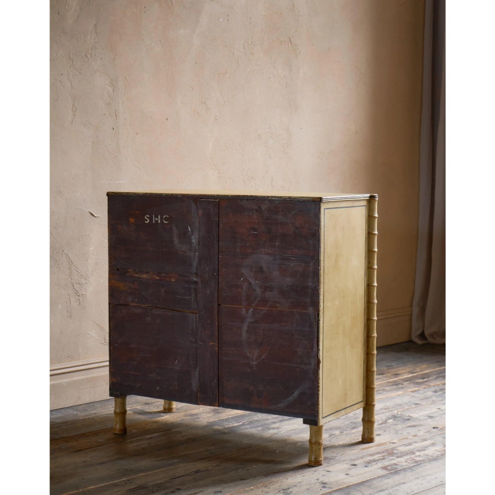 A Regency pale yellow painted chest of drawers featuring simulated bamboo turned corner columns and dark turned knobs. View V
