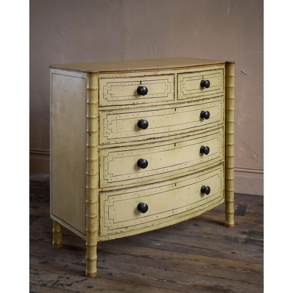 A Regency pale yellow painted chest of drawers featuring simulated bamboo turned corner columns and dark turned knobs. View VII