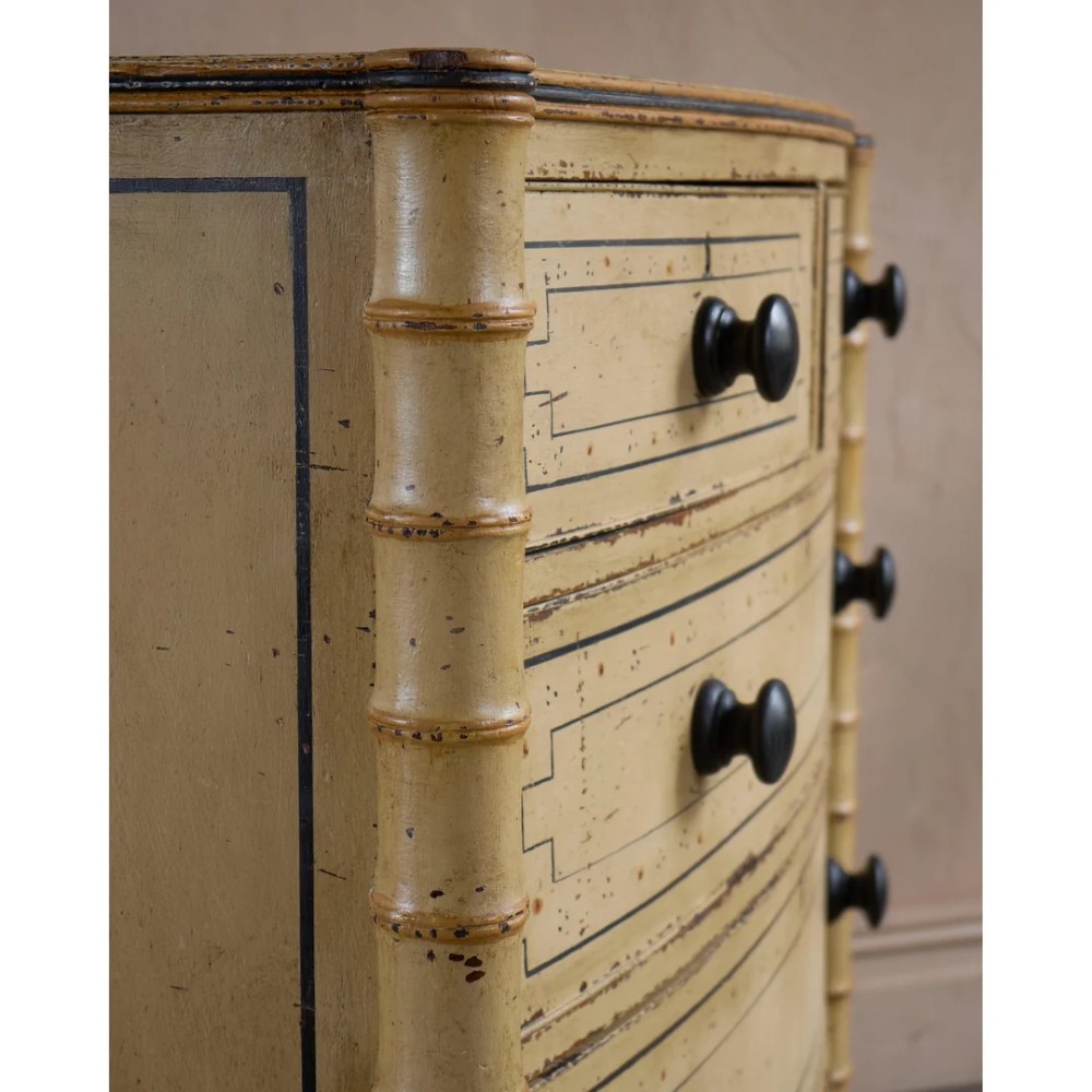 A Regency pale yellow painted chest of drawers featuring simulated bamboo turned corner columns and dark turned knobs. View IX