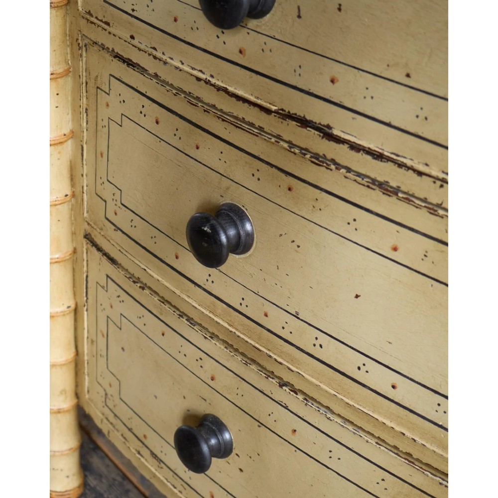 A Regency pale yellow painted chest of drawers featuring simulated bamboo turned corner columns and dark turned knobs. View XI