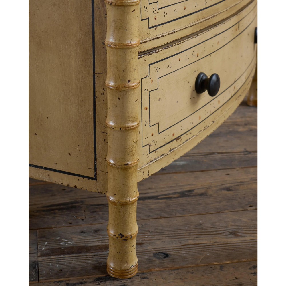 A Regency pale yellow painted chest of drawers featuring simulated bamboo turned corner columns and dark turned knobs. View XV