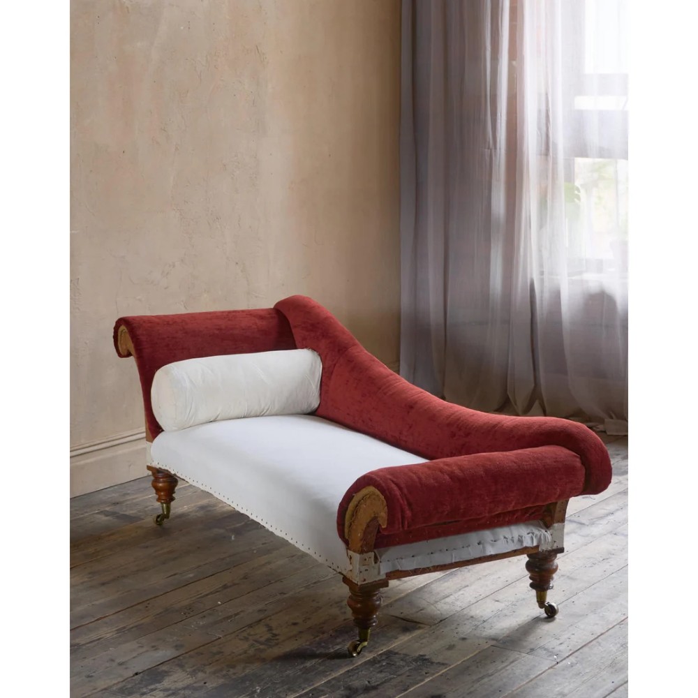 A Victorian asymmetrical chaise longue featuring red velvet and white calico fabric upholstery set on turned mahogany legs with brass castors. View VI