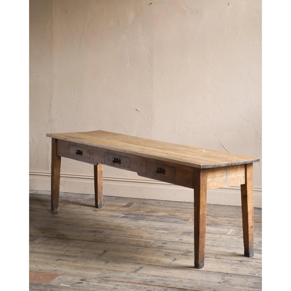 A long natural pine scullery table featuring three drawer fronts with dark wooden knobs and straight legs. View II