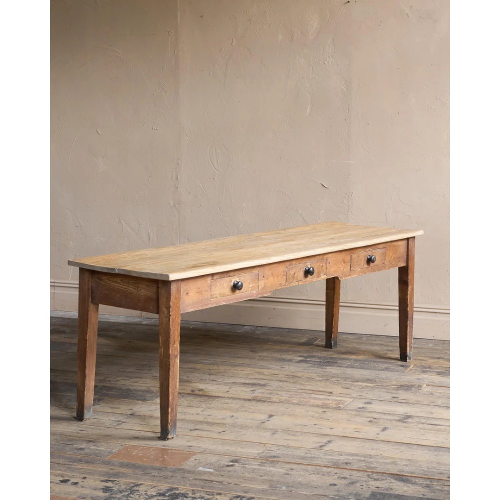 A long natural pine scullery table featuring three drawer fronts with dark wooden knobs and straight legs. View IV