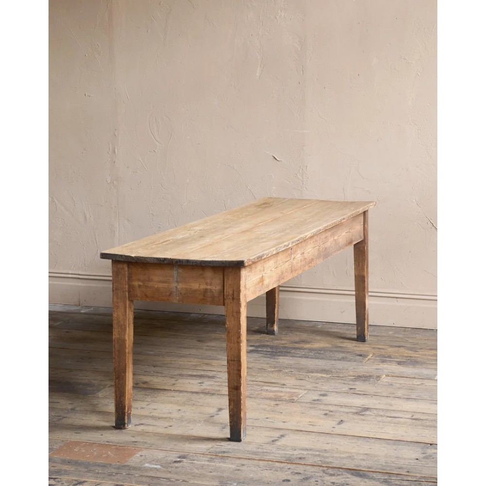 A long natural pine scullery table featuring three drawer fronts with dark wooden knobs and straight legs. View V